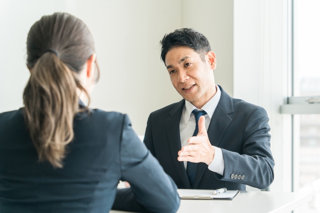 商談中に熱心に説明をするスーツ姿の男性

